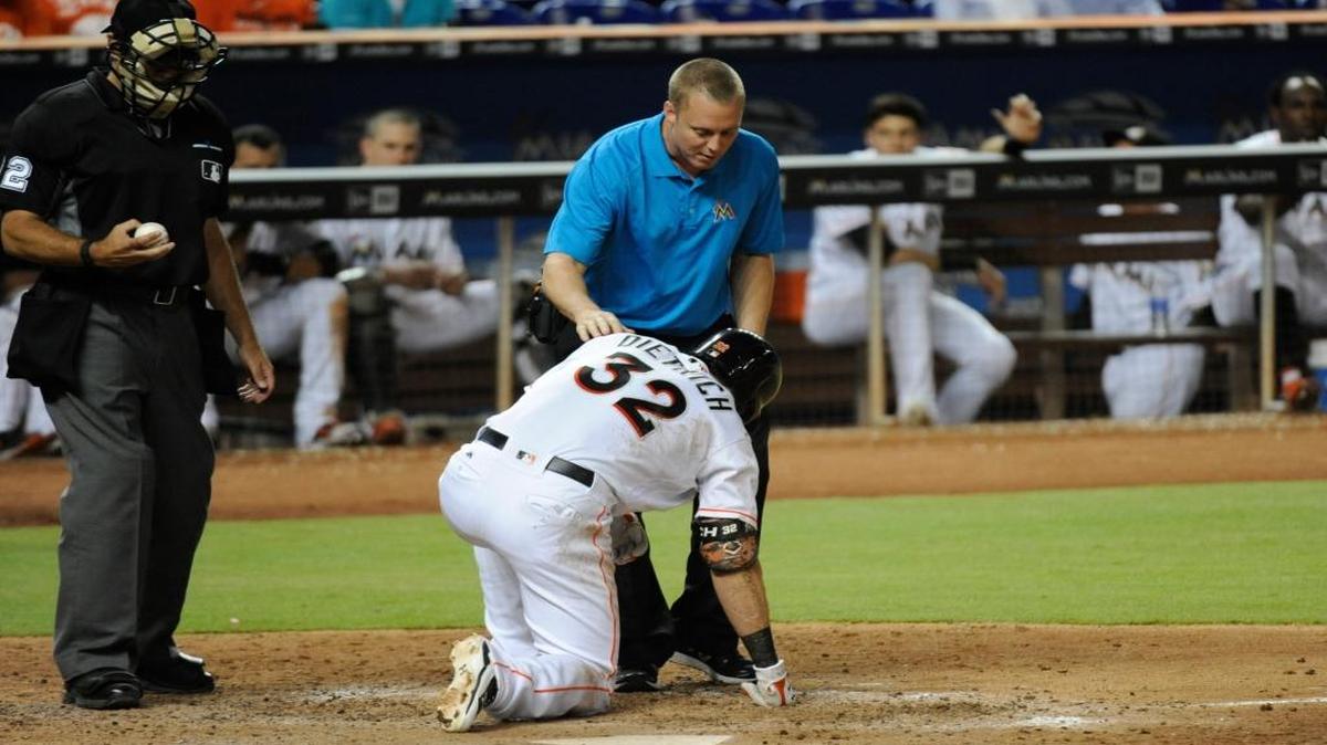 DEREK DIETRICH es atendido por el entrenador Dustin Luepker tras ser golpeado por un lanzamiento el 1 de junio.