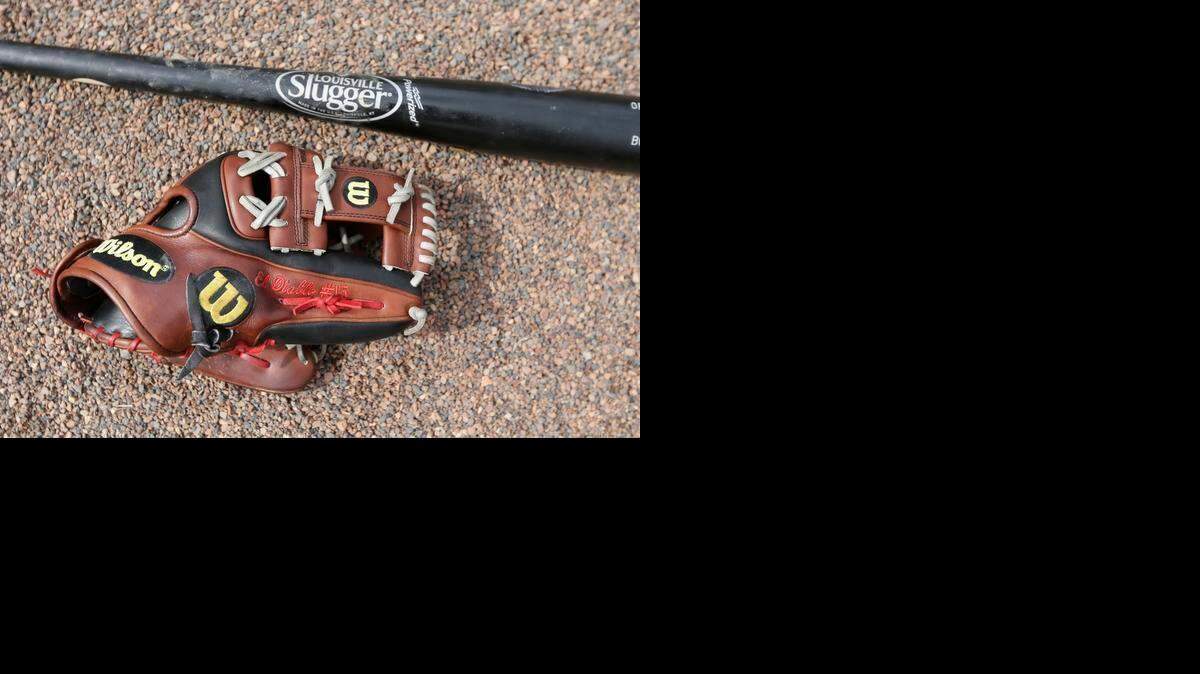 Un guante de Wilson y un bate de Louisville Slugger se ven en el campo antes de un partido de exhibición de béisbol de entrenamiento de primavera entre los Bravos de Atlanta y los Medias Rojas de Boston en Kissimmee , Fla el viernes , 27 de marzo de 2015.
