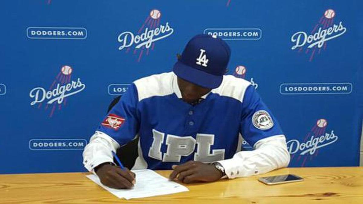 
El pitcher cubano Yadiel Álvarez firma su bono de $16 millones con los Dodgers, el jueves 2 de julio del 2015.
