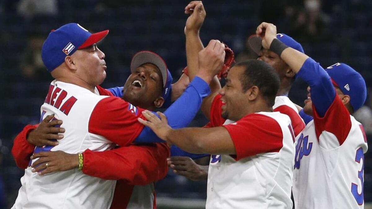 El cerrador cubano Miguel Lahera (izq.) celebra con sus compañeros la victoria 4-3 ante Australia como parte del Clásico Mundial de Béisbol, el viernes en el Tokyo Dome en Japón.