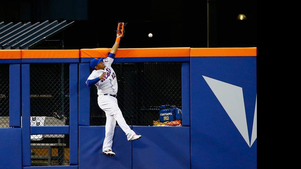 
El dominicano de los Mets Juan Lagares se estira y no llega a la pelota que bota Giancarlo Stanton, el viernes.
