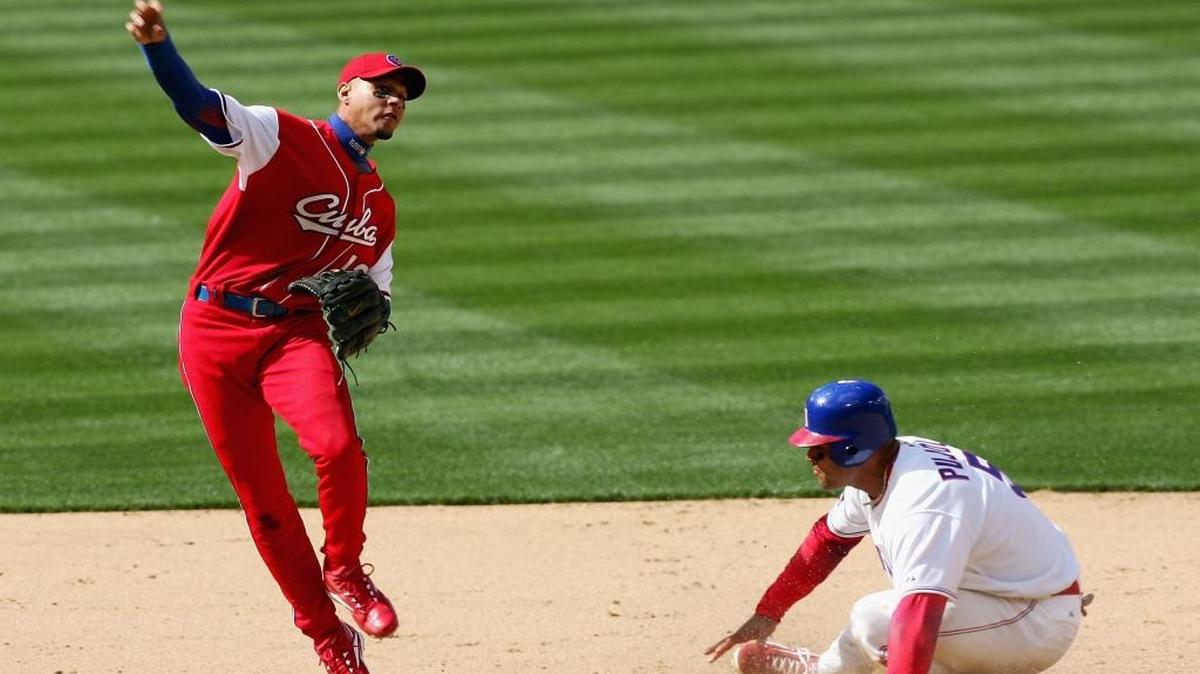 EL PELOTERO cubano Yulieski Gourriel retorna la bola a primera base mientras que el dominicano Albert Pujols se desliza en segunda durante el partido entre Cuba y Dominicana en el Clásico Mundial de Béisbol el 18 de marzo del 2006, en el Petco Park de San Diego, California.