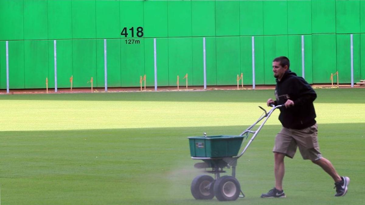 UN TRABAJADOR pasa delante de los pilotes que marcan las nuevas dimensiones por la pradera central del parque de los Marlins el 19 de enero.