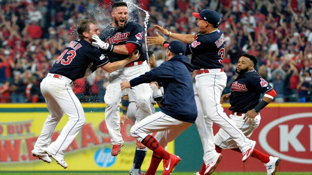 Yan Gomes, segundo desde la izq., celebra con los Indios luego de disparar el hit triunfal contra los Yankees, el viernes.