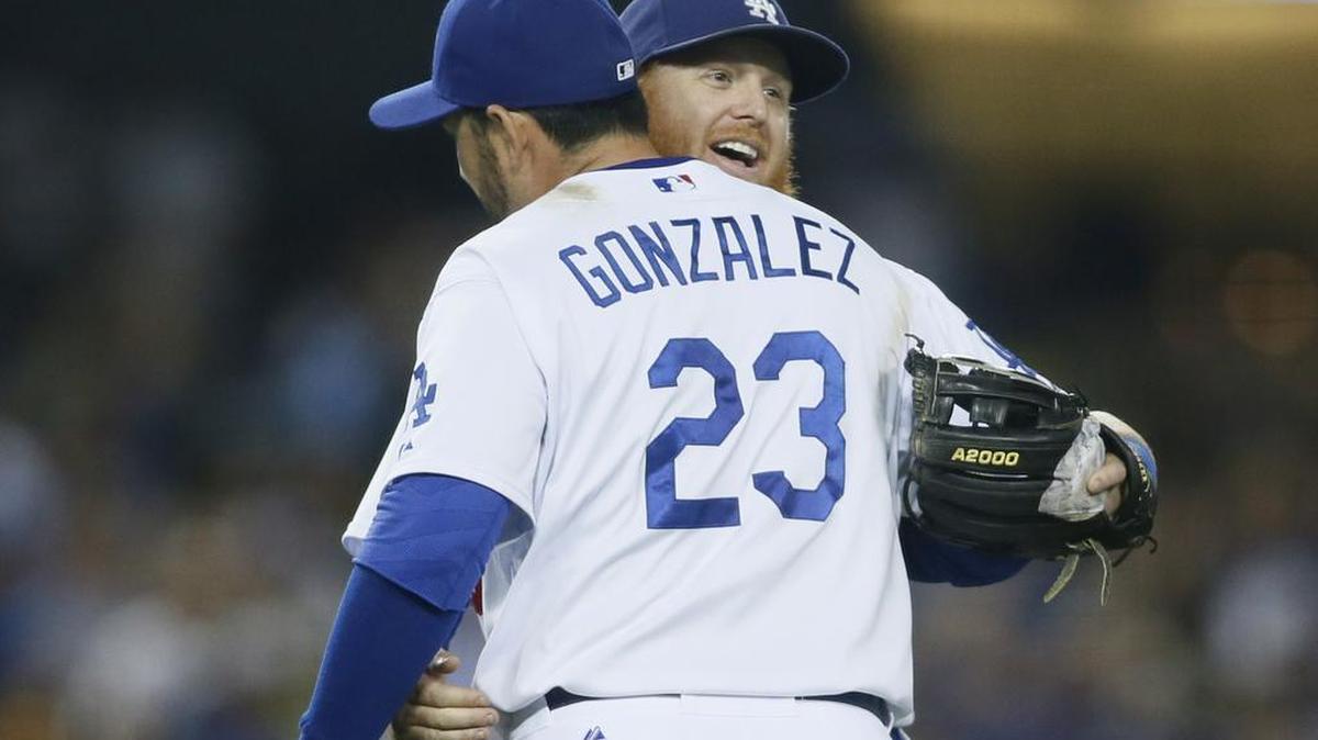 El tercera base de los Dodgers de Los Ángeles, Justin Turner, celebra con el mexicano Adrián González el triunfo sobre los Padres de San Diego el sábado 3 de octubre de 2015, en Los Ángeles.