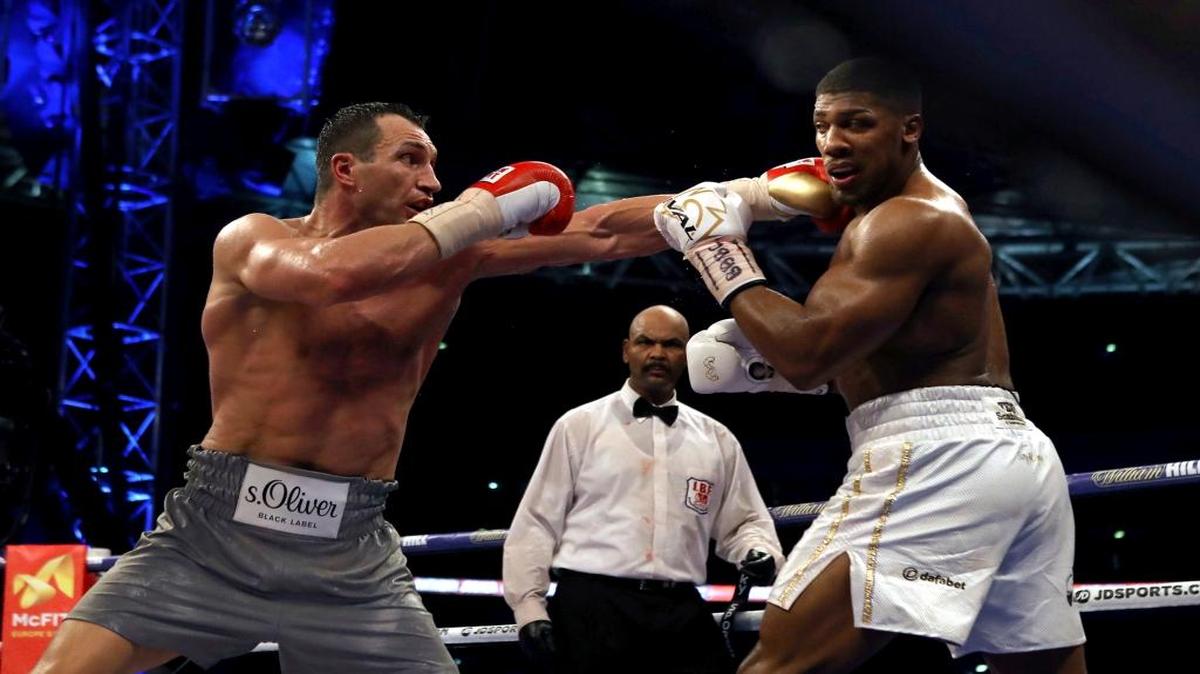 El británico Anthony Joshua (der.) intercambia golpes con el ucraniano Wladimir Klitschko, en la pelea en el estadio Wembley, en Londres, el sábado 29 de abril del 2017.