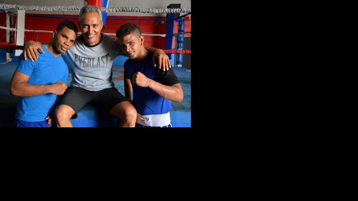 
Los peleadores cubanos Hairon Socarrás (izq.) y Neslán Machado posan con el entrenador Jorge Rubio en un gimnasio en Miami.
