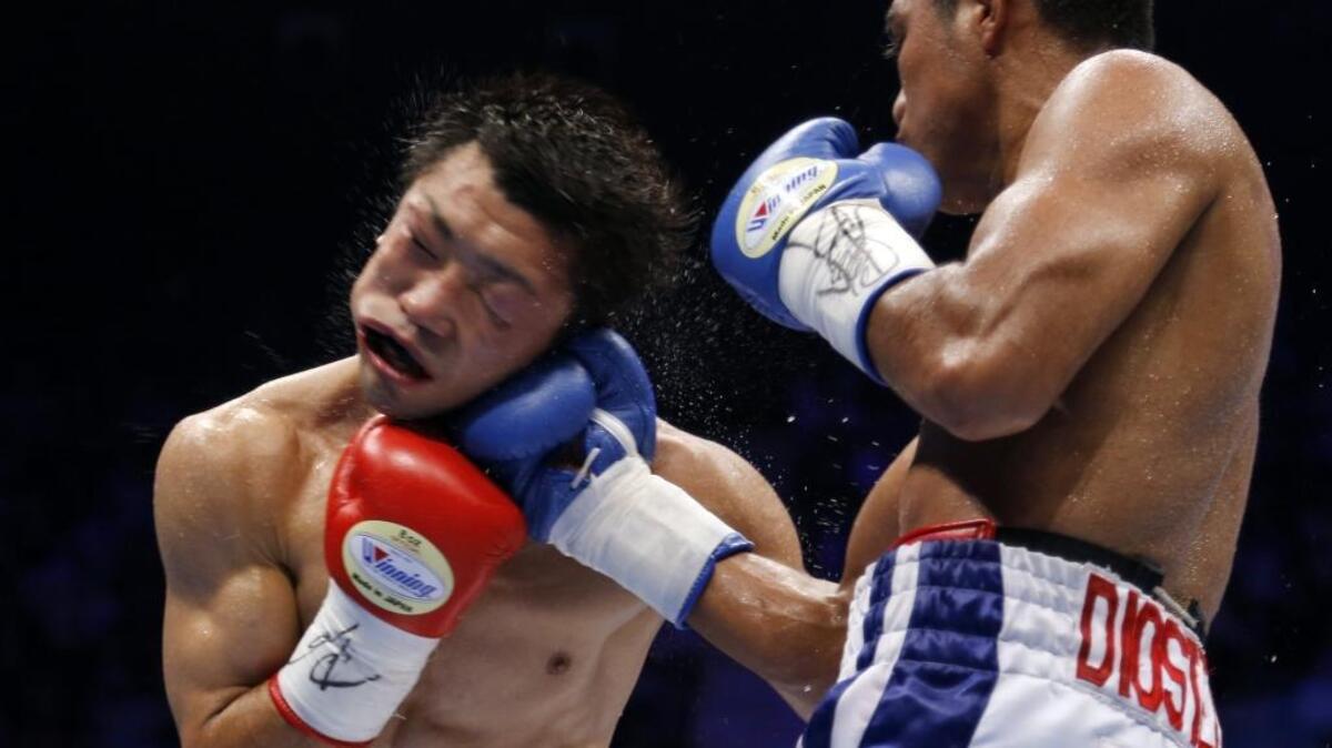 El nicaragüense Román González (der.) golpea a japonés Akira Yaegashi, el 5 de septiembre del 2014 en Tokio.