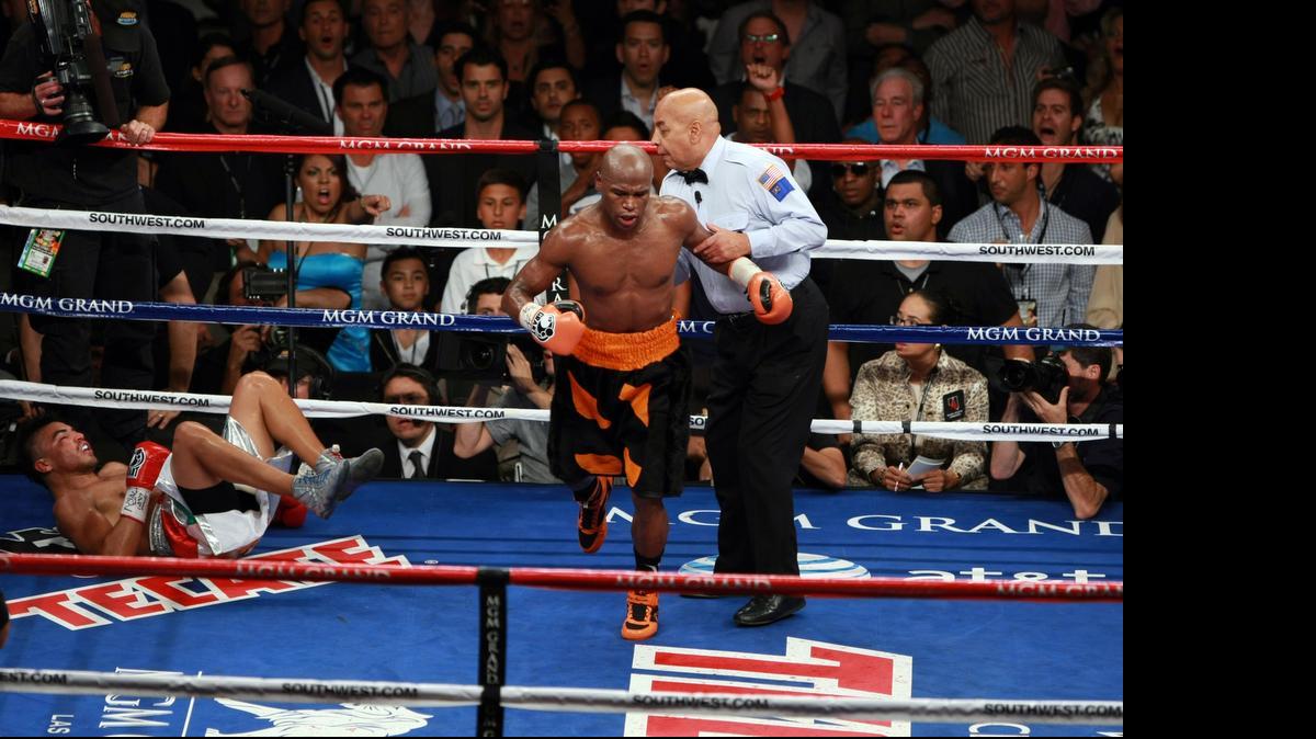 
Joe Cortez envía a Floyd Mayweather a la esquina en la pelea con Víctor Ortiz, el 17 de septiembre del 2011.
