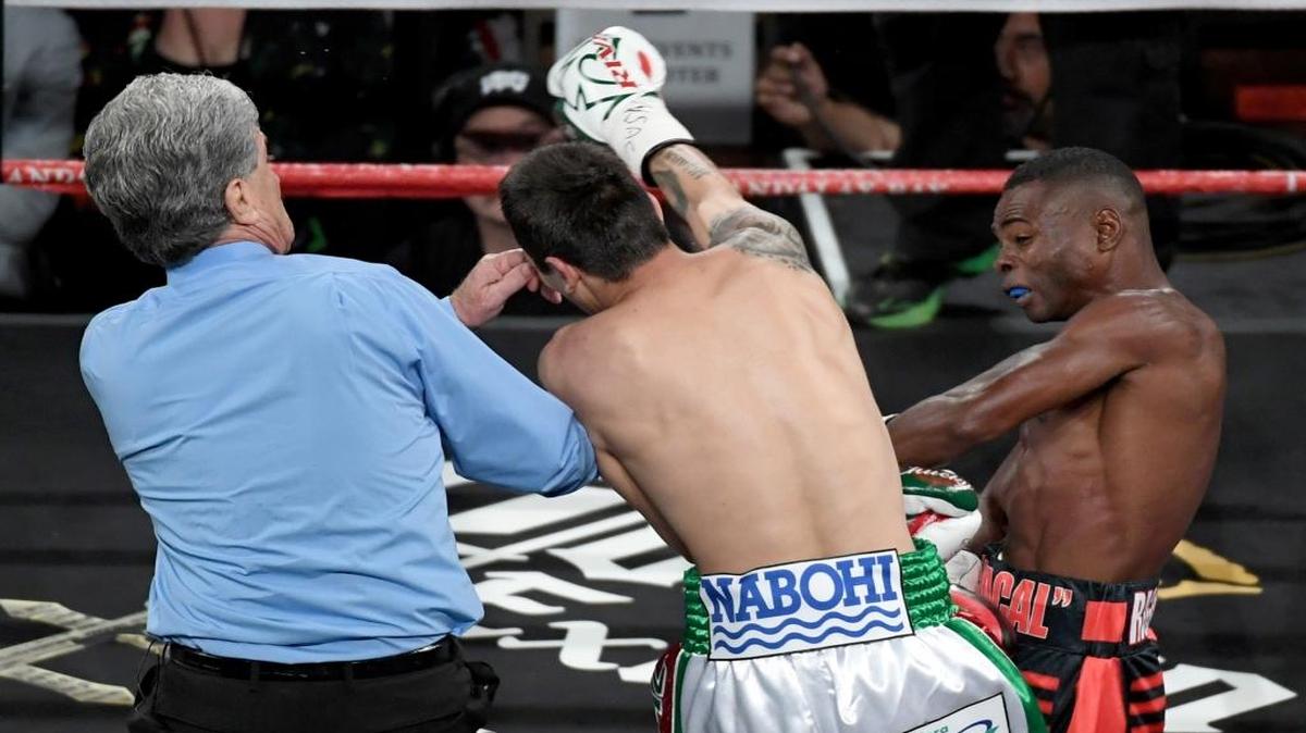 EL ARBITRO Vik Drakulich intenta separar a Moisés Flores (c) y a Guillermo Rigondeaux (d) al final del primer asalto de su pelea en Las Vegas.