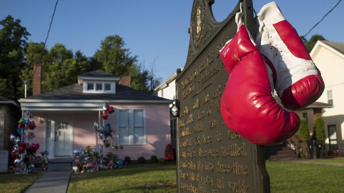 UN PAR de guantes de boxeo cuelgan en la placa que marca el hogar de infancia de Muhammad Ali en Lousville, Kentucky, el 10 de junio del 2016.