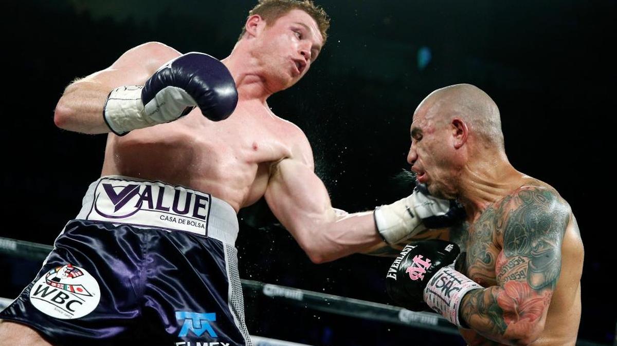 El mexicano Canelo Álvarez lanza la izquierda a Miguel Cotto, de Puerto Rico, en la pelea por la corona de los medianos del Consejo Mundial de Boxeo, el sábado 21 de noviembre del 2015, en Las Vegas.