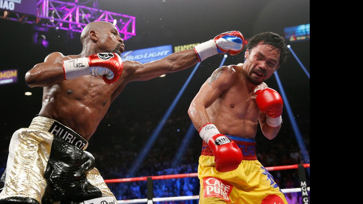 
Floyd Mayweather Jr. lanza su izquierda contra Manny Pacquiao, la noche del sábado 2 de mayo del 2015 en Las Vegas.
