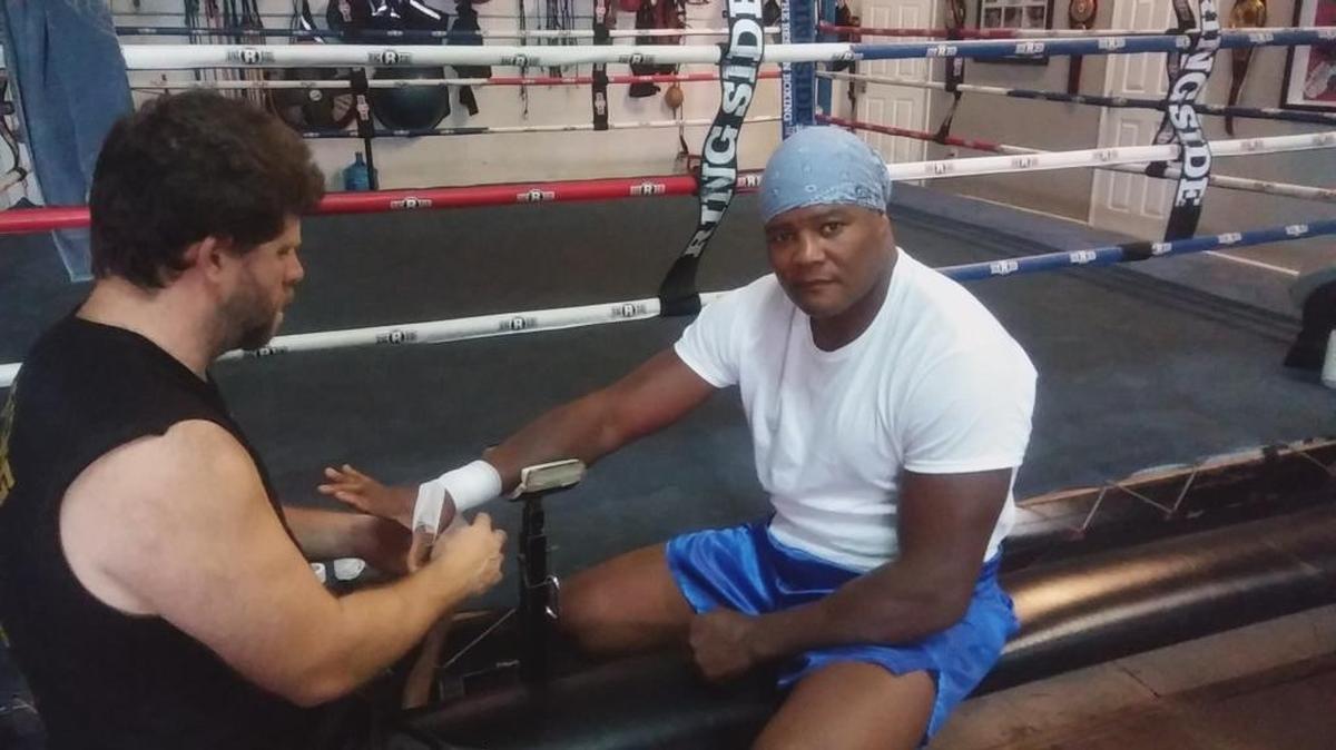 GERMAN CAICEDO, entrenador de Luis Ortiz, venda las manos del gigante antes de comenzar sparrings en su gimnasio de Miami.