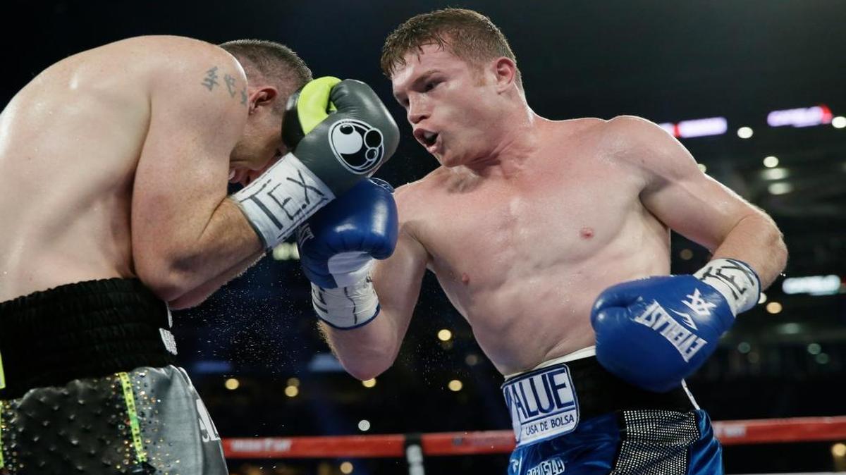 Canelo Álvarez (der.) golpea a Liam Smith en la pelea por la corona de los mediano juniors de la OMB, ante más de 51,000 fanáticos en el estadio en Arlington, Texas, el 17 de septiembre del 2016. Álvarez ganó por KO en el noveno.