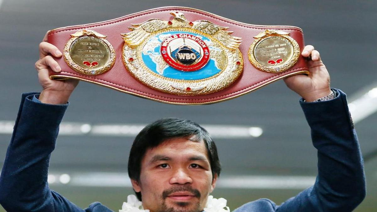 Manny Pacquiao levanta su faja de campeón welter de la Organización Mundial de Boxeo, en el aeropuerto internacional Ninoy Aquino, en la ciudad de Pasay, al sureste de Manila, Filipinas, el 8 de noviembre del 2016.
