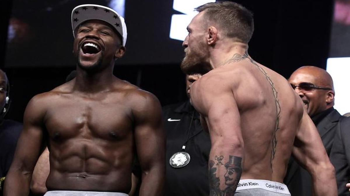 El boxeador Floyd Mayweather Jr. y el luchador de MMA Connor Mcgregor posan durante su pesaje el 25 de agosto de 2017, en Las Vegas, Nevada.