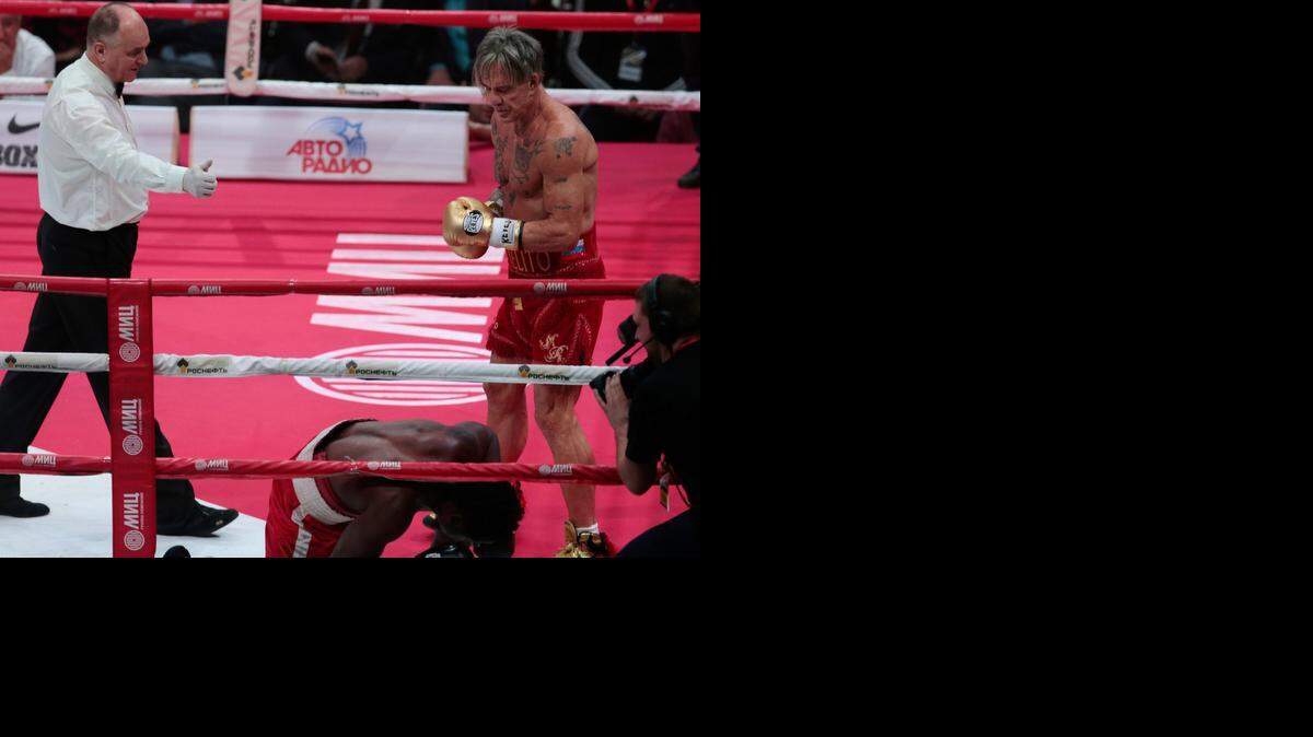 
Mickey Rourke (der.) mira a su oponente Elliot Seymour, que queda en el piso durante la pelea disputada en Moscú el viernes.
