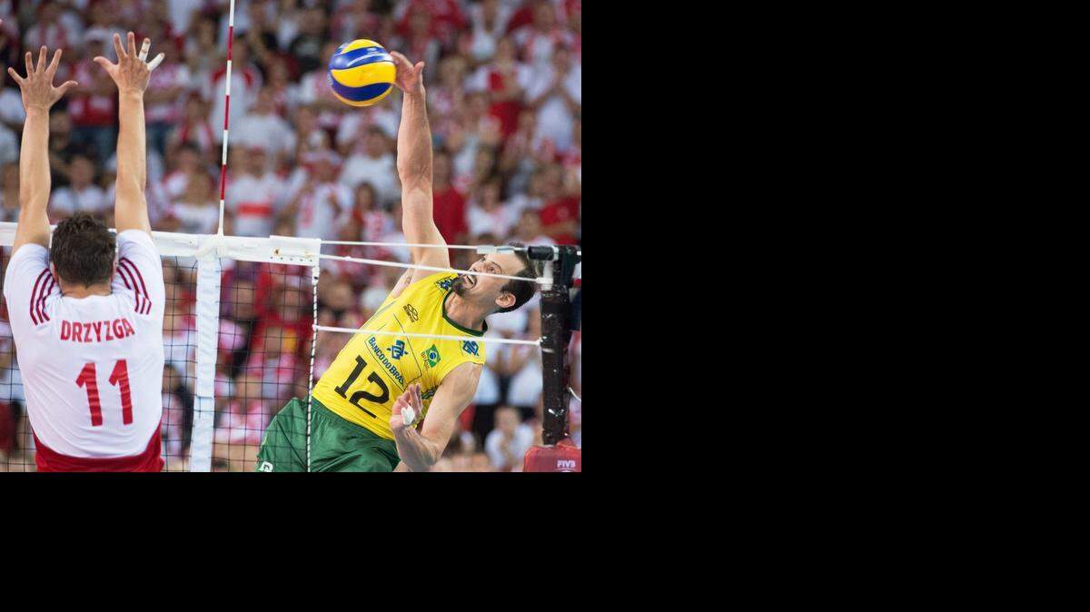 
El brasileño Luiz Felipe (#12) ataca el balón ante el bloqueo del polaco Fabian Drzyzga #11).


