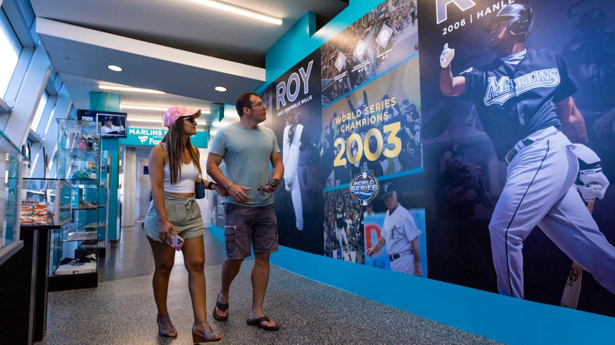 Jeff Campbell, de 40 años, y Luana Fureando, también de 40, mirando los carteles expuestos en Miami Marlins 30th Anniversary History Museum, dentro de loanDepot Park, el miércoles 17 de mayo de 2023.