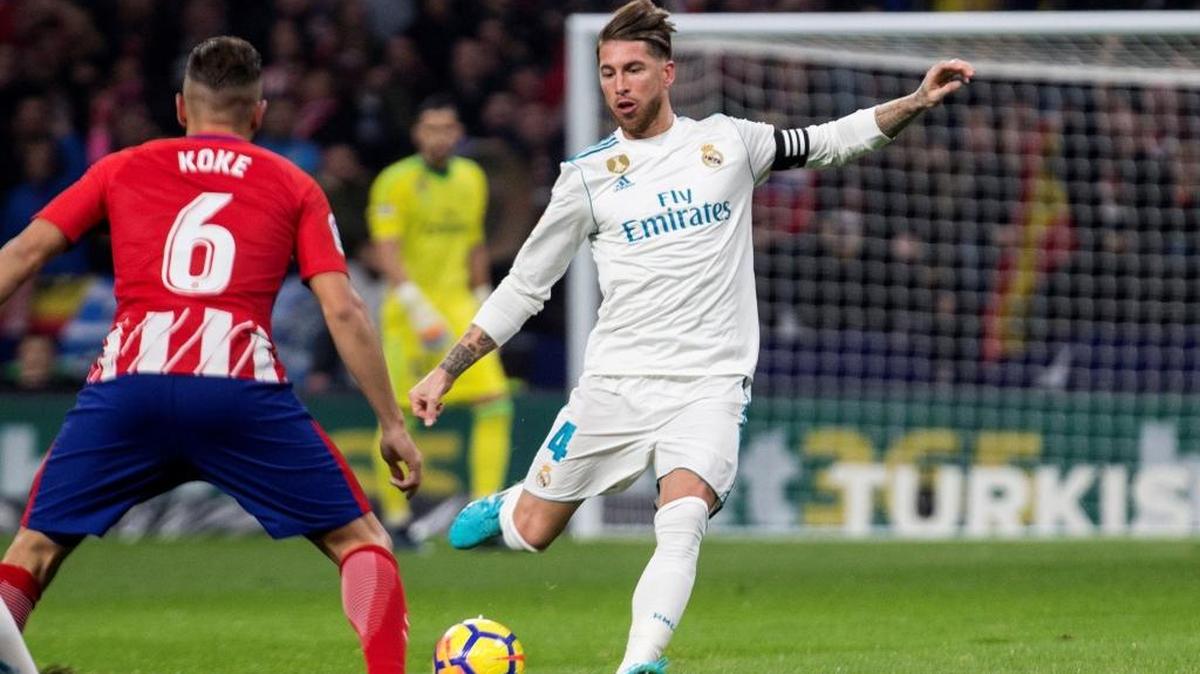 El defensa del Real Madrid Sergio Ramos (d) patea un balón ante el centrocampista del Atlético de Madrid "Koke" Resurrección en partido de la 12da jornada de liga en Primera División disputado el sábado en el estadio Wanda Metropolitano.