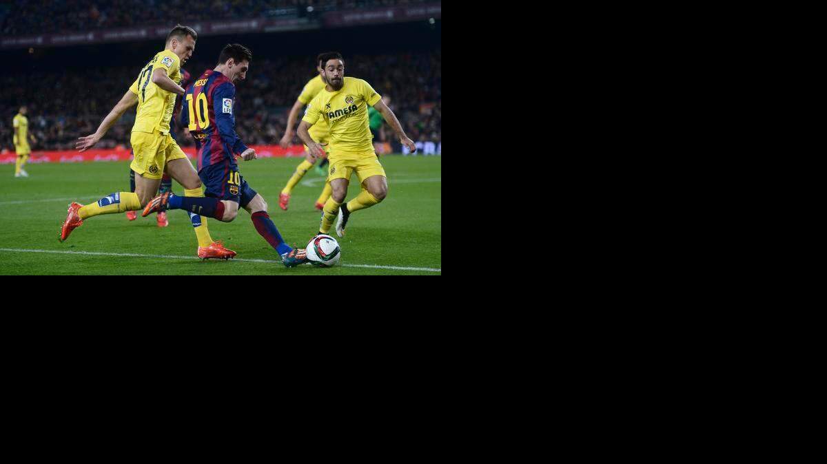 
El argentino Lionel Messi trata de superar la marca de dos jugadores del Villarreal, en el partido de ida de la Copa del rey, el 11 de febrero en Barcelona.


