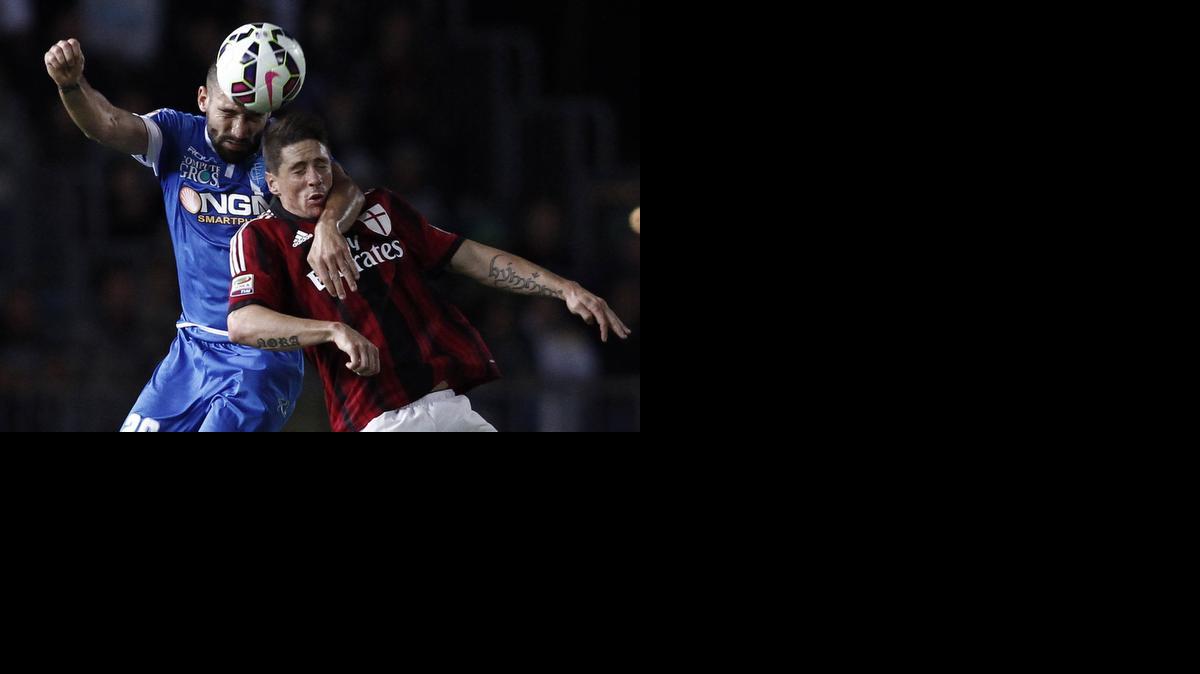 
El delantero del Milan Fernando Torres pugna por el esférico con el defensor del Empoli Lorenzo Tonelli.


