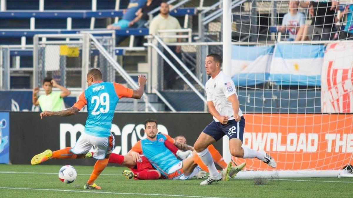 Stefano Pinho, del Miami FC, remata mientras su compañero Vincenzo Rennella queda tendido junto con el arquero Kyle Nesta, del Armada, y Kalen Ryden (22) no puede evitar la anotación, la noche del sábado 17 de junio del 2017 en el Riccardo Silva Stadium (FIU) en Miami.
