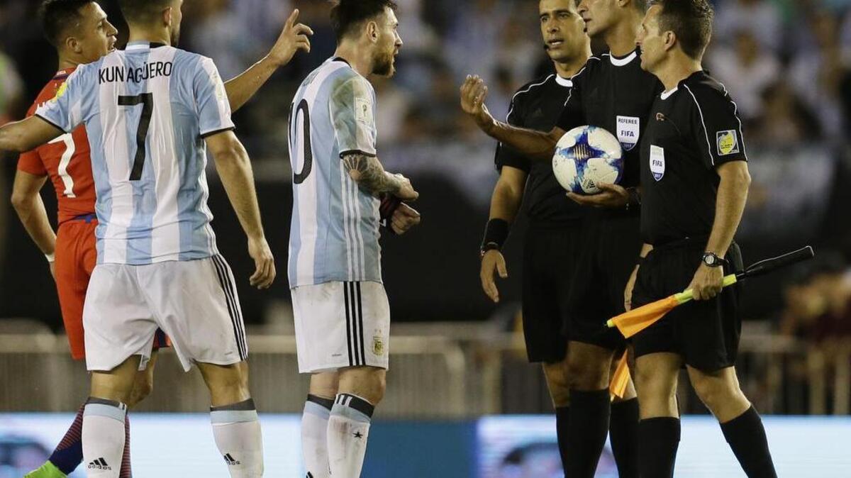 El capitán de Argentina Lionel Messi habla con los árbitros al término del partido contra Chile el 23 de marzo. Messi fue sancionado con cuatro partidos por insultar a uno de ellos durante el partido.
