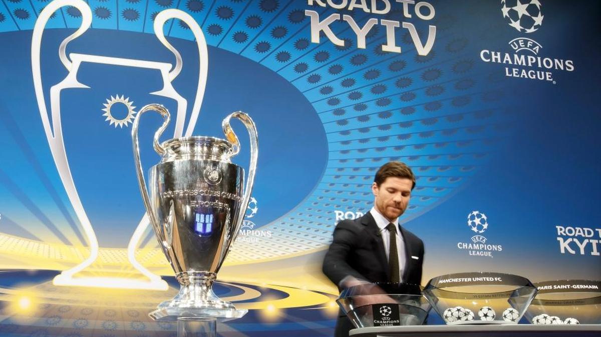 El español Xabi Alonso, quien fuera jugador del Liverpool, Real Madrid y Bayern saca una de las bolas del bombo en el sorteo de la Champions celebrado este lunes en Nyon, Suiza.