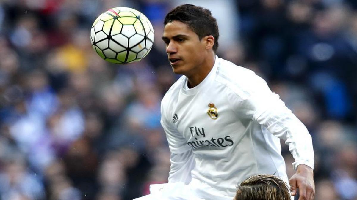 El defensa del Real Madrid Raphael Varane (izq.) pelea un balón con el delantero del Atlético de Madrid Fernando Torres, durante el encuentro de la vigésima sexta jornada de liga española, que se disputó el 27 de febrero del 2016.