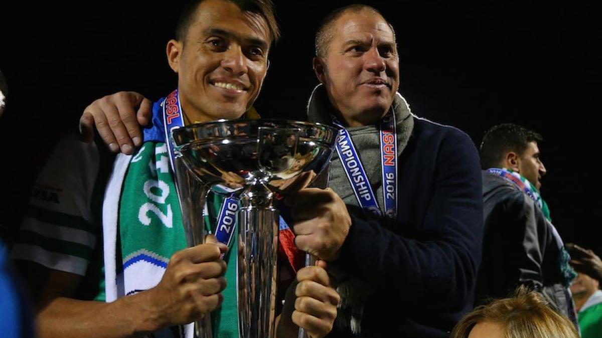 Juan Arango (izq.) y Giovanni Savarese, del Cosmos celebran con el trofeo de campeón la conquista del título de la NASL, el 13 de noviembre del 2016 en Nueva York.