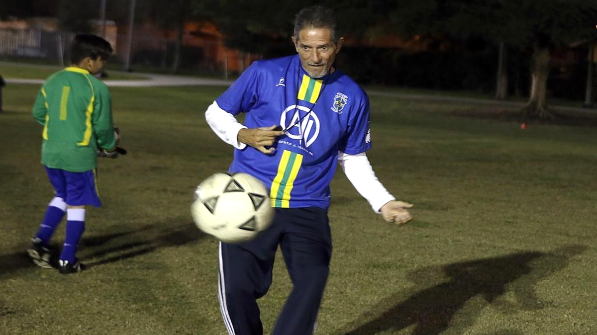 El entrenador de fútbol Juan A. Lotina enseña a sus pupilos de la academia ‘Jogo Bonito’ el golpeo del balón duranten una práctica el 22 de noviembre en el North Trail Park en Miami.