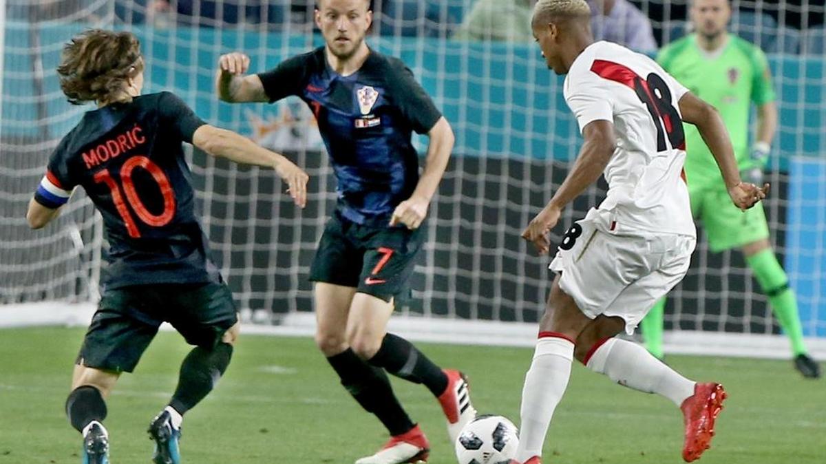 El delantero Andre Carrillo (#18) autor del primer gol de Perú trata de evadir la marca de los volantes de Croacia Ivan Rakitic (#7) y Luka Modric (#10) en el partido amistoso de este 23 de marzo Hard Rock Stadium en Miami Gardens.