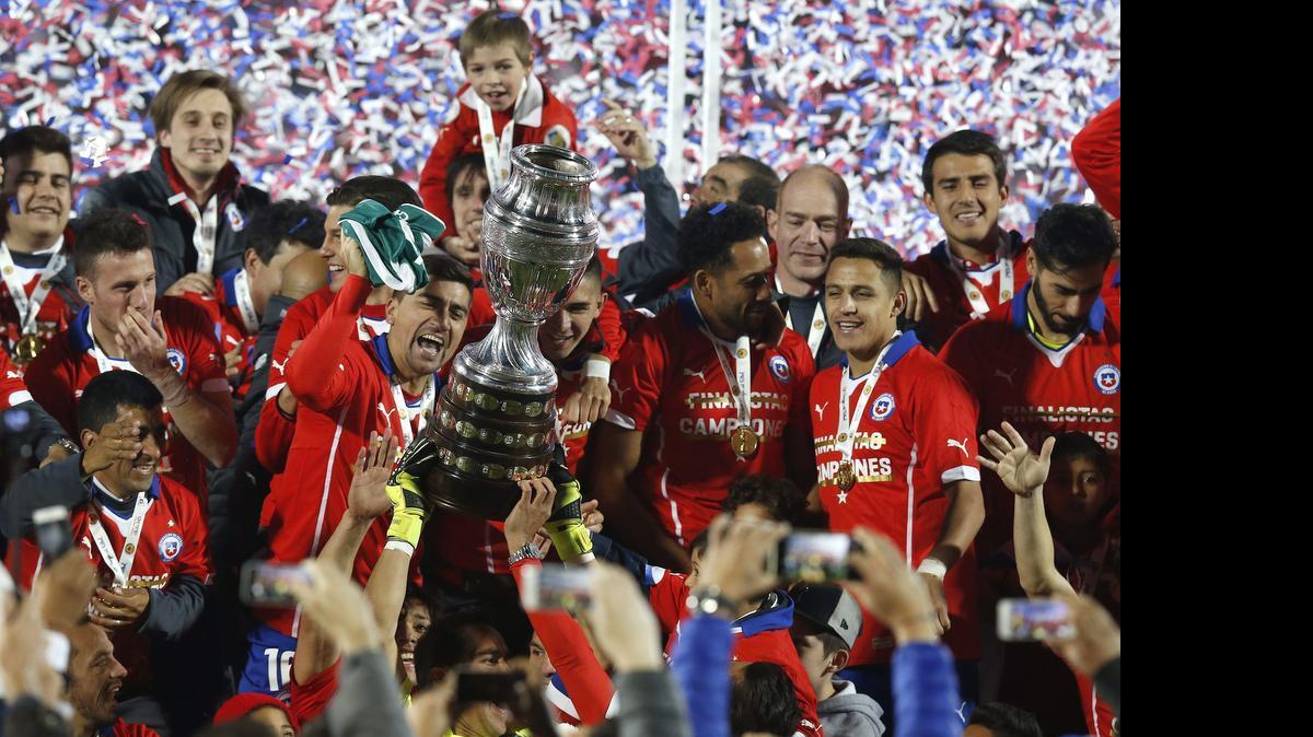 
Los jugadores de Chile posan con el trofeo que les acredita vencedores de la Copa América de Chile 2015, tras la final disputada frente a Argentina en el Estadio Nacional Julio Martínez Prádanos de Santiago de Chile, Chile, hoy 4 de julio de 2015. 
