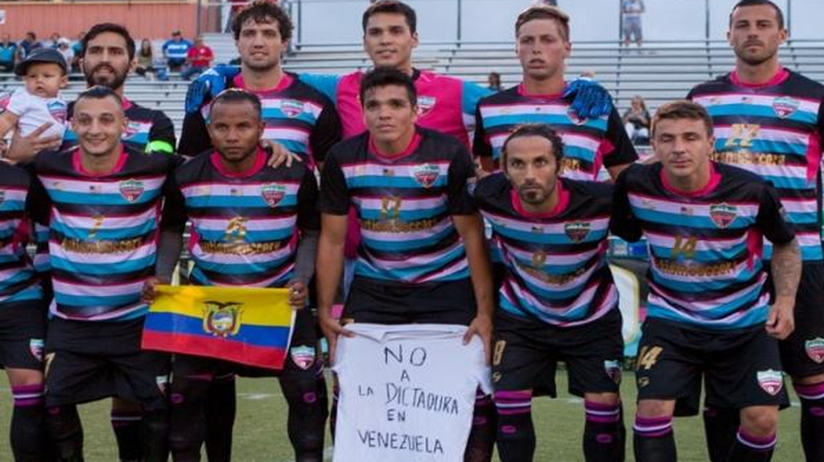 El Miami United FC se forma para el partido contra el Boca Raton FC, por el campeonato de la Sunshine Conference de la National Premier Soccer League, el domingo 30 de abril del 2017 en el Ted Hendricks Stadium en Hialeah, Florida. El capitán Ezequiel Tejera tiene en brazos a su hijo Matías; Max Rodríguez luce la bandera ecuatoriana; y el exseleccionado de la vinotinto Juan Fuenmayor muestra un mensaje contra la dictadura de Venezuela. También aparece Bazuca, la mascota del equipo.