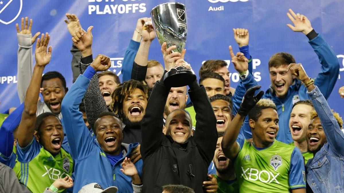 El capitán de los Sounders Osvaldo Alonso, rodeado por varios jugadores del equipo de Seattle, levanta el trofeo de campeón de la Conferencia Este, tras vencer en la final al Houston Dynamo, con un global de 5-0, el 30 de noviembre en Seattle.