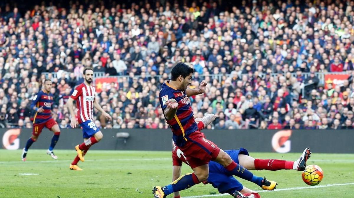Luis Suárez, del Barcelona, dispara a puerta y le anota pese al esfierzo de Diego Godín, del Atlético Madrid, el 30 de enero del 2016.
