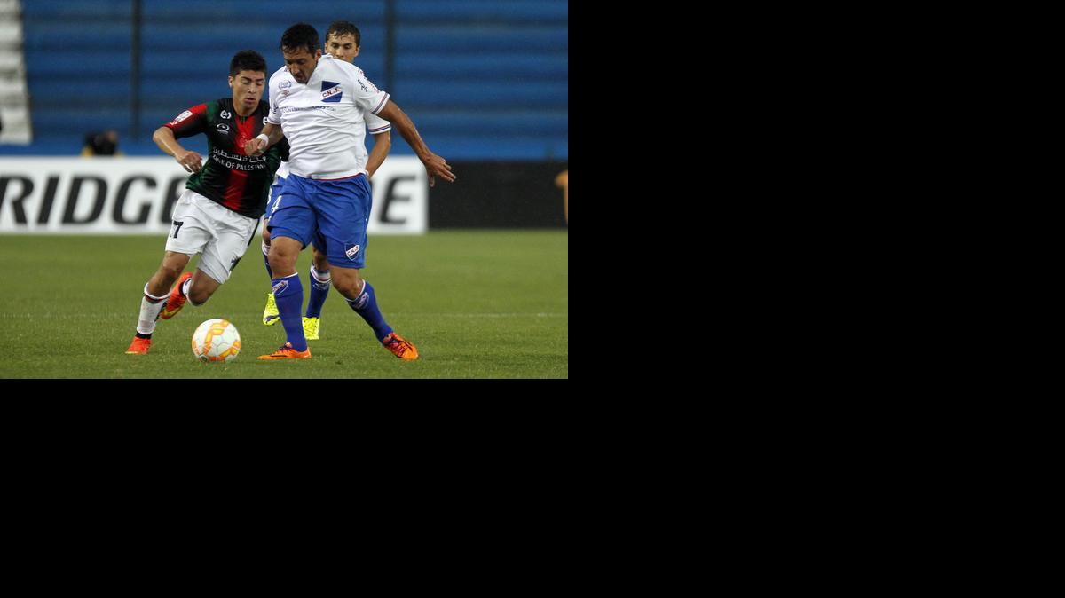 
El jugador del Nacional de Uruguay Fabián Porras, der., disputa el balón con Esteban Carvajal de Palestino. 

