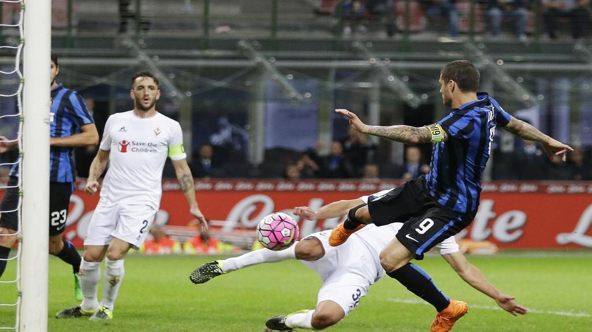 
El delantero argentino del Inter Mauro Icardi ( der.) anota el gol de la honrilla en la goleada sufrida por la Fiorentina en San Siro, el 29 de septiembre del 2015.
