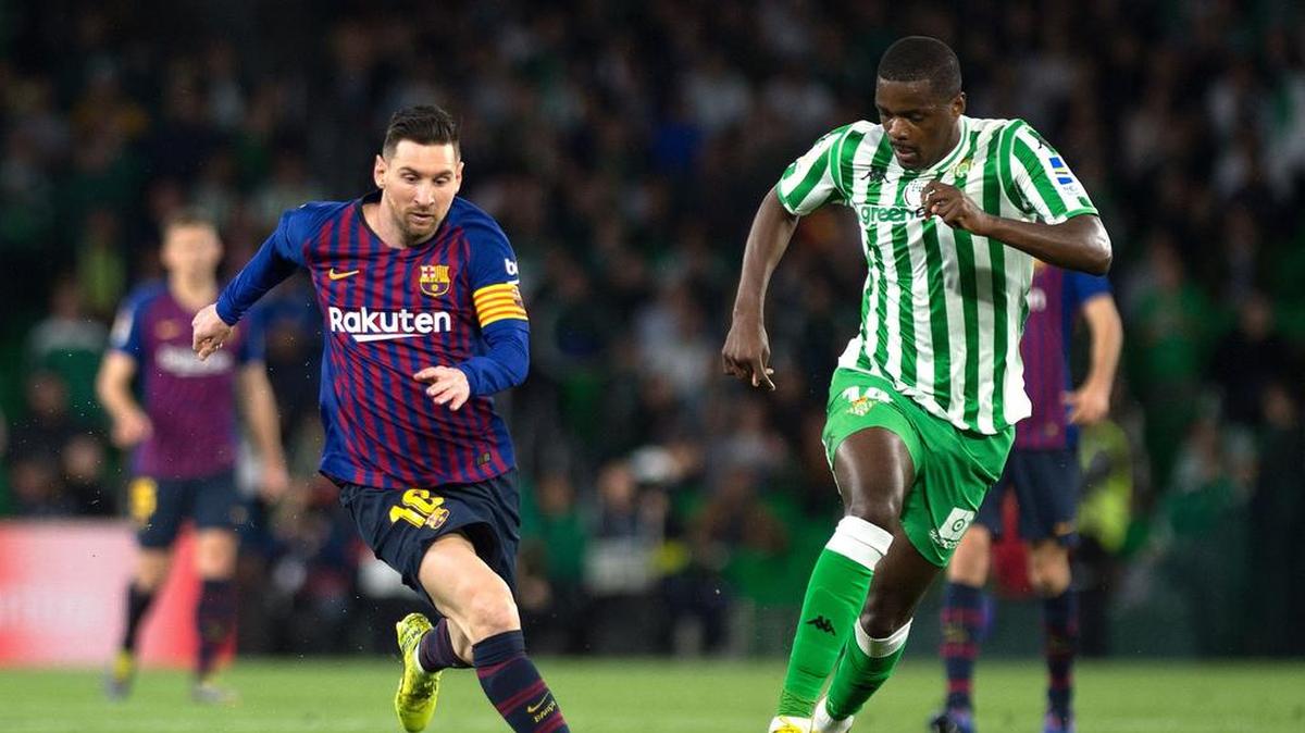 Lionel Messi (izq.) conduce el balón por Barcelona ante la marca de William Carvalho, del Betis, en el partido efectuado el 17 de marzo de 2019.