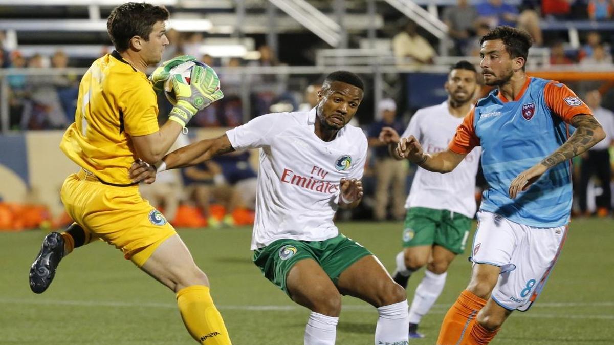 El arquero del Cosmos Jimmy Maurer ataja la bola acosado por Vincenzo Rennella (8), del Miami FC, en el Riccardo Silva Stadium, la noche del sábado 8 de abril del 2017.