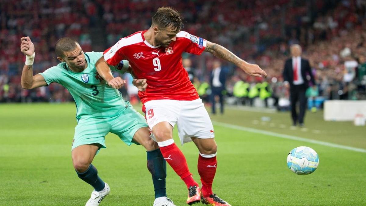 El defensa de Portugal Pepe (izq.) trata de arrebatarle el balón a Haris Seferovic, de Suiza, en la primera fecha de la eliminatorias al Mundiaal de Rusia-2018.
