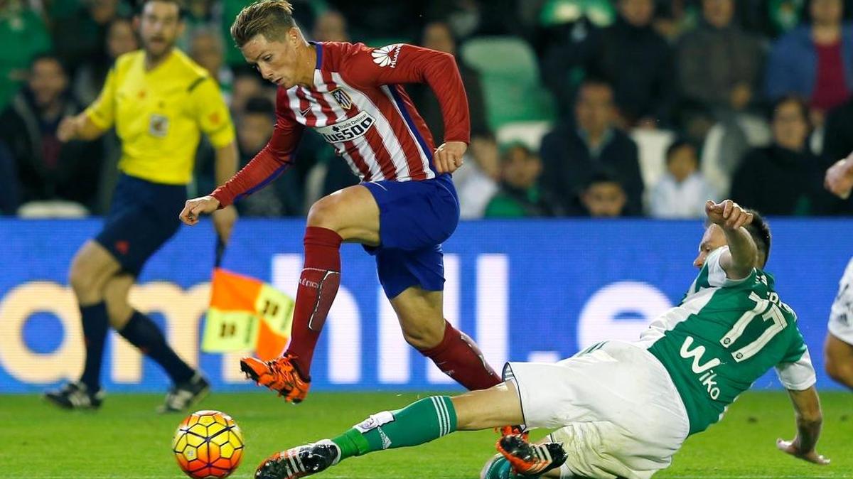 El delantero del Atlético de Madrid Fernando Torres (izq.) se escapa del defensa Heiko Westermann, del Betis, en el triunfo rojiblanco.