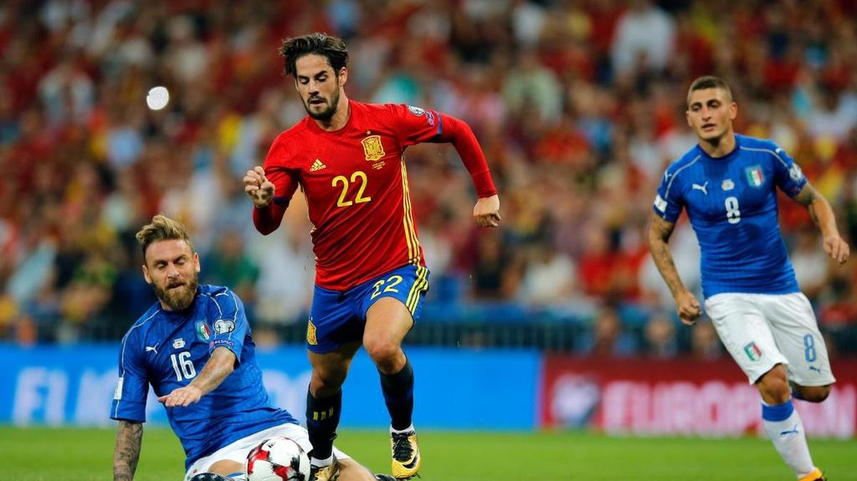 Isco (22), de España, supera a Daniele De Rossi (16), de Italia, el sábado en el estadio Santiago Bernabéu, en Madrid.