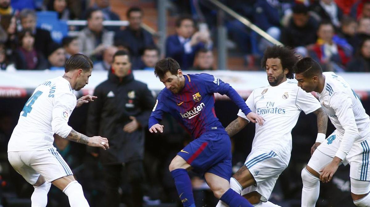 El delantero de Barcelona Lionel Messi (centro) trata de pasar entre Sergio Ramos (izq.), Marcelo y Casemiro (der.), del Real Madrid, en el partido efectuado el 23 de diciembre de 2017 en el estadio Santiago Bernabéu en la capital española.