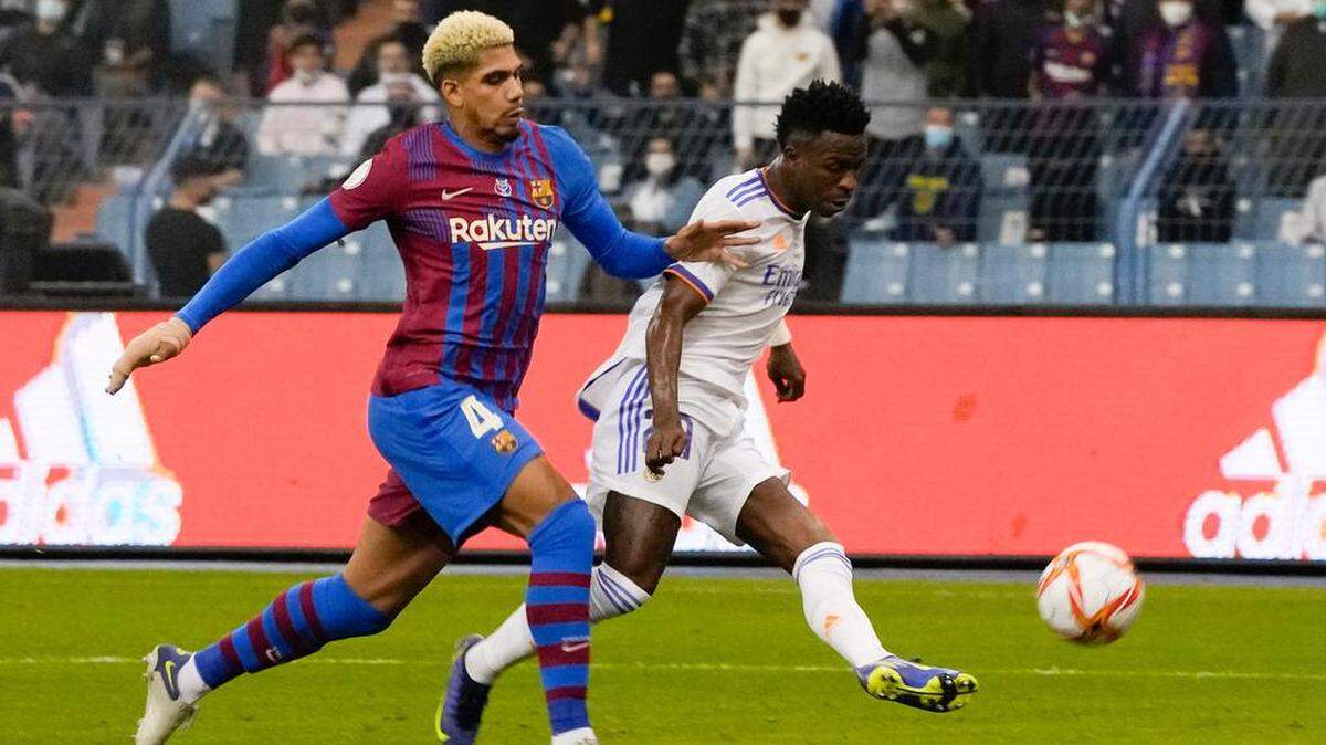 Vinicius Junior, del Real Madrid, en acción para anotar por Ronald Araujo del Barcelona durante el partido de fútbol de semifinales de la Supercopa de España entre el Barcelona y el Real Madrid en el estadio Rey Fahd en Riyadh, Arabia Saudita, el miércoles 12 de enero de 2022.