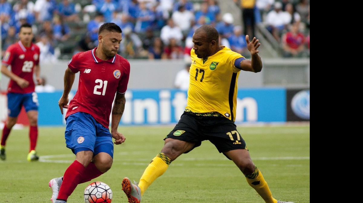 
David Ramírez (izq.), de Costa Rica, trata de evadir a Rodolph Austin, de Jamaica en el empate 2-2 en el Grupo B.
