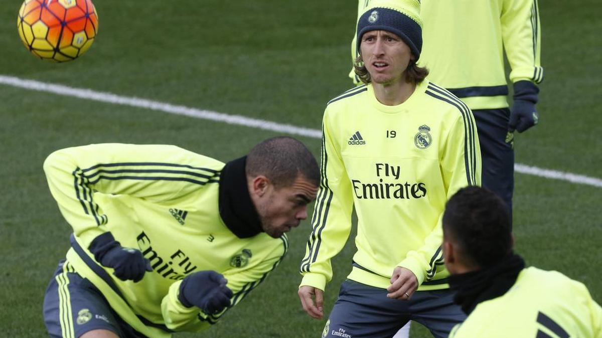 Los jugadores del Real Madrid, el croata Luka Modric (d) y el portugués Kléper Laveran "Pepe" (i), durante el entrenamiento realizado hoy en la Ciudad Deportiva de Valdebebas para preparar el partido de la décimo novena jornada de Liga que les enfrenta al Deportivo de La Coruña mañana en el estadio Santiago Bernabéu, encuentro con el que el nuevo entrenador, el francés Zinedine Zidane, debuta al frente del conjunto blanco.