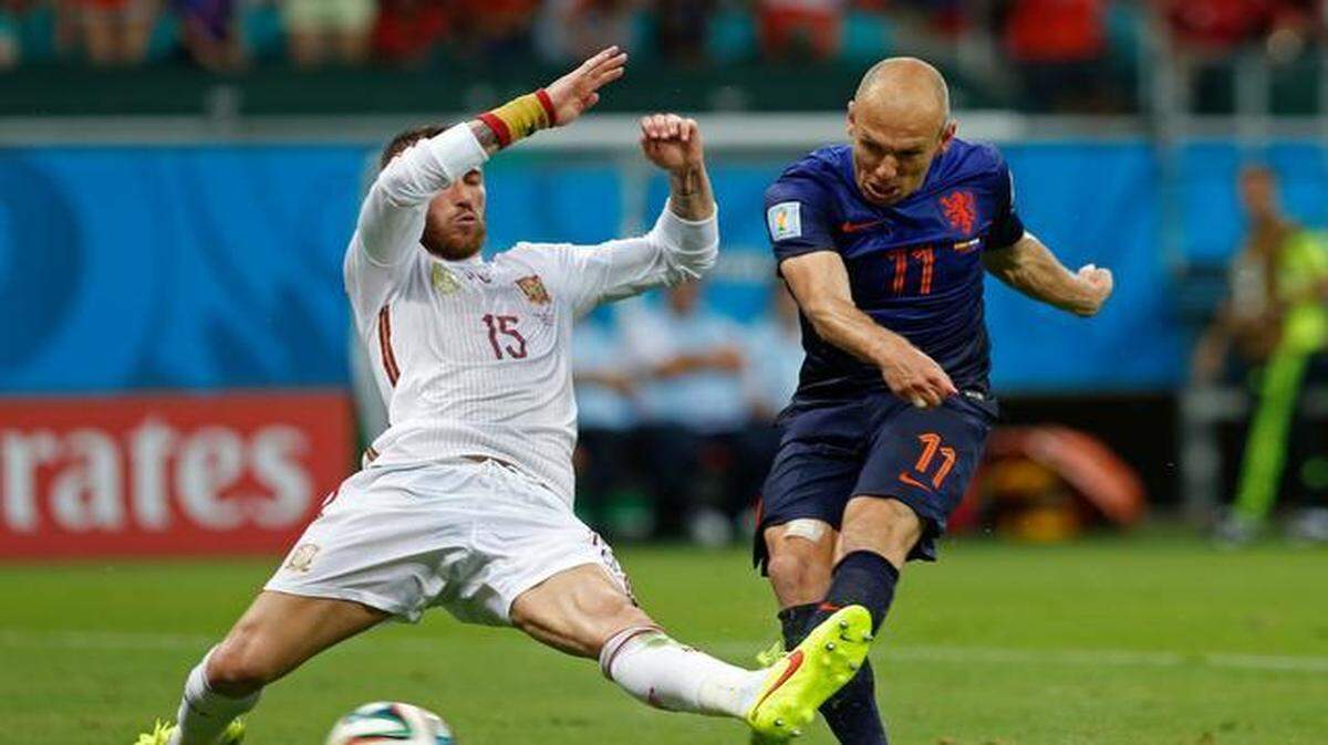 
Arjen Robben, de Holanda, dispara a puerta y anota pese al esfuerzo de Sergio Ramos, de Espana, en el Mundial de Brasil 2014.


